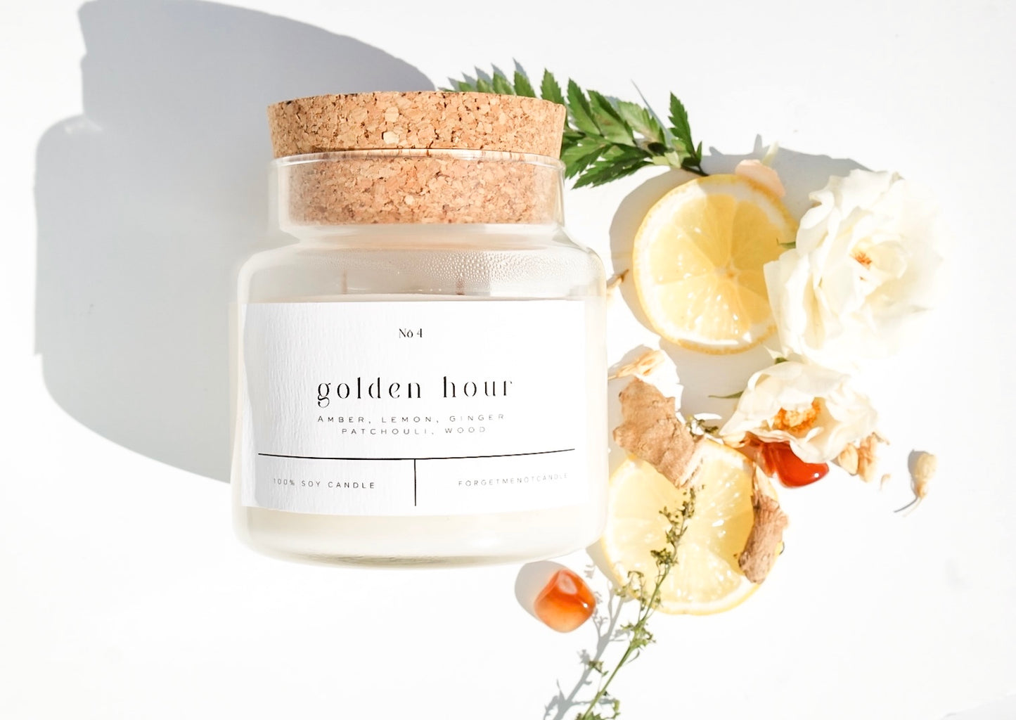 Golden Hour 100% soy wax candle with cork lid, styled with fresh lemon slices, ginger root, and flowers. Hand-poured, eco-friendly candle featuring a blend of amber, lemon, ginger, patchouli, and wood for a non-toxic, clean fragrance.